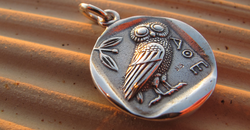 Wise owl coin pendant photographed outdoors